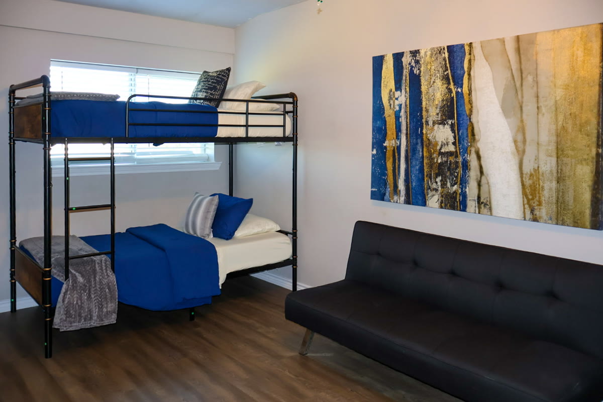 A bright bedroom on the ranch with bunk beds and a sofa