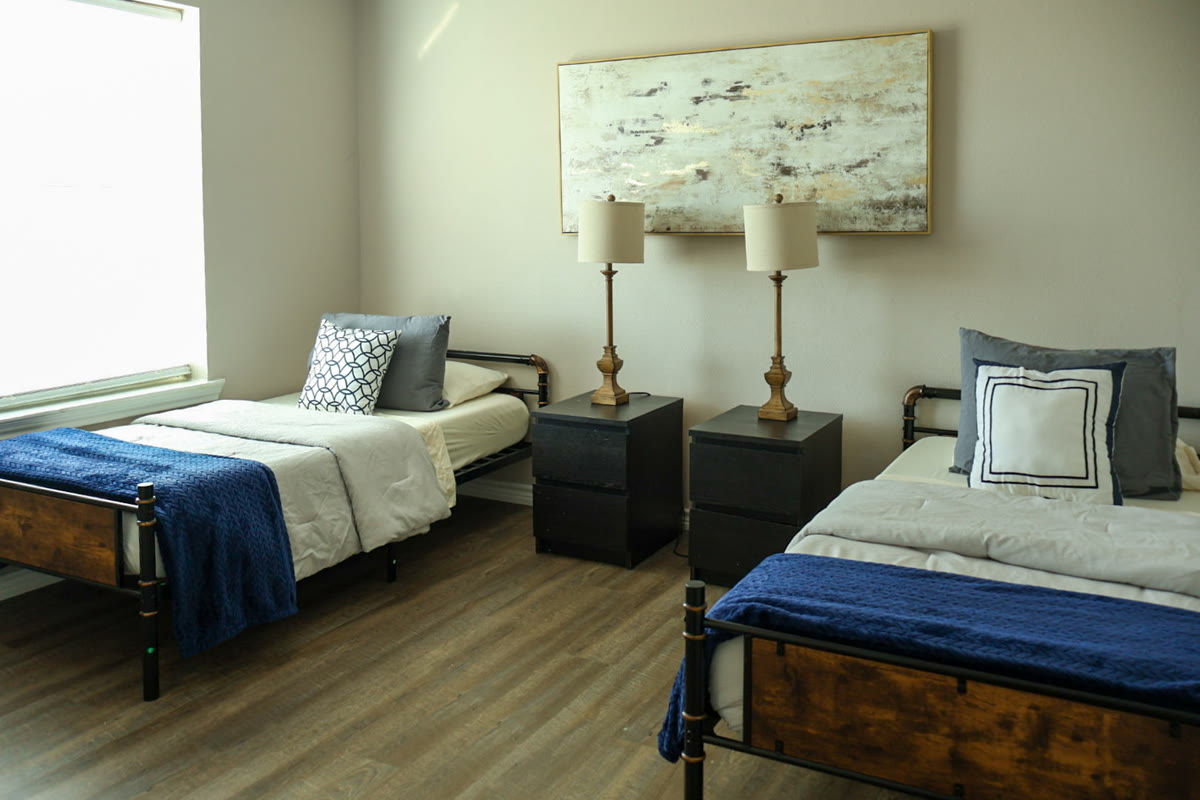 A tidy bedroom on the ranch with twin beds, lamps and soft light