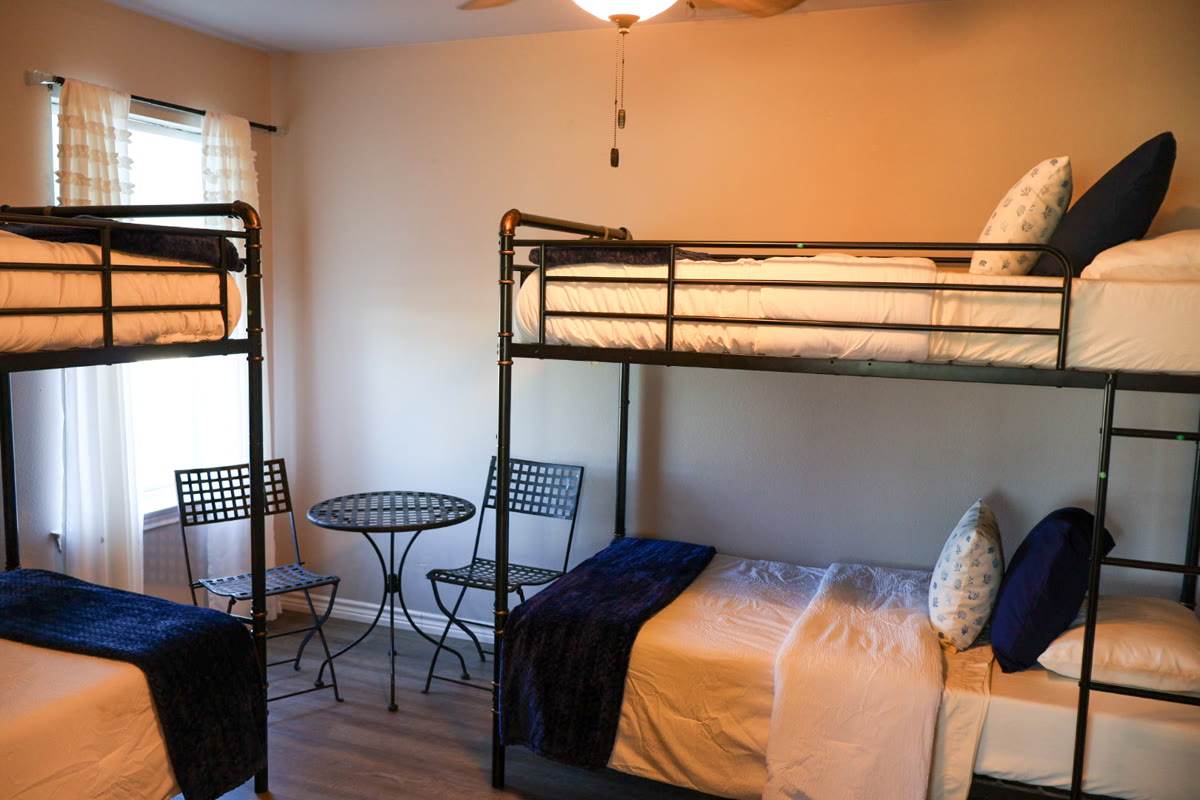 A comfortable bedroom on the ranch with bunk beds and a small table