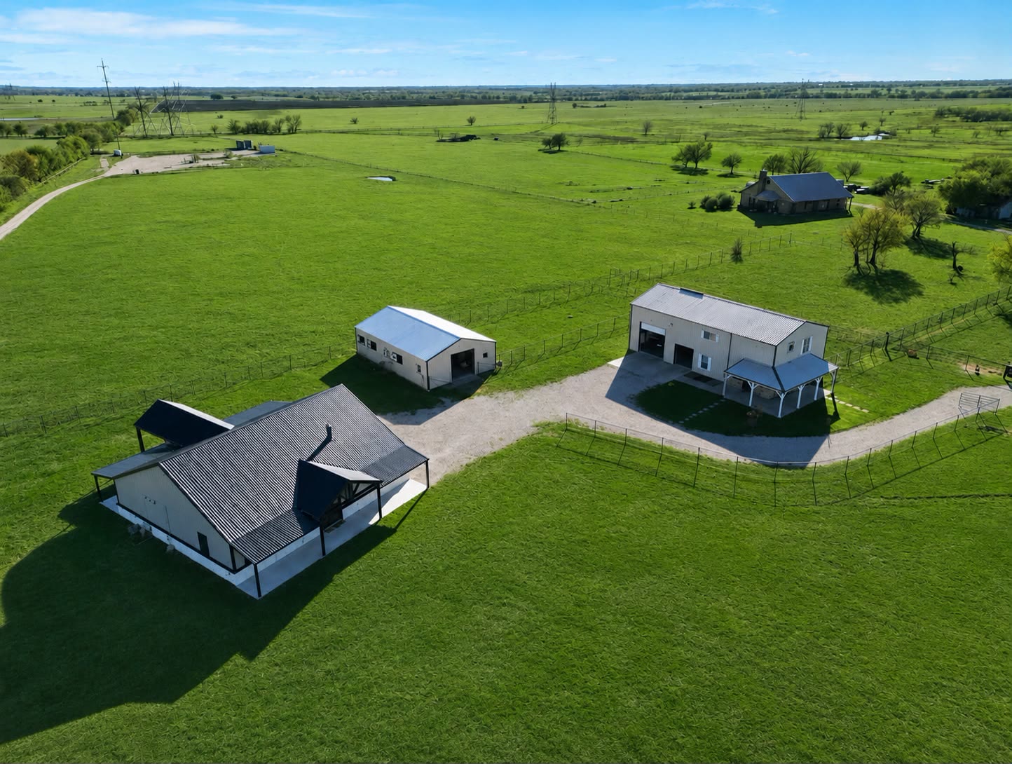 Aerial view of the AyaWaken Ranch near Dallas, Texas: the ceremony barn and lodge on open green pasture